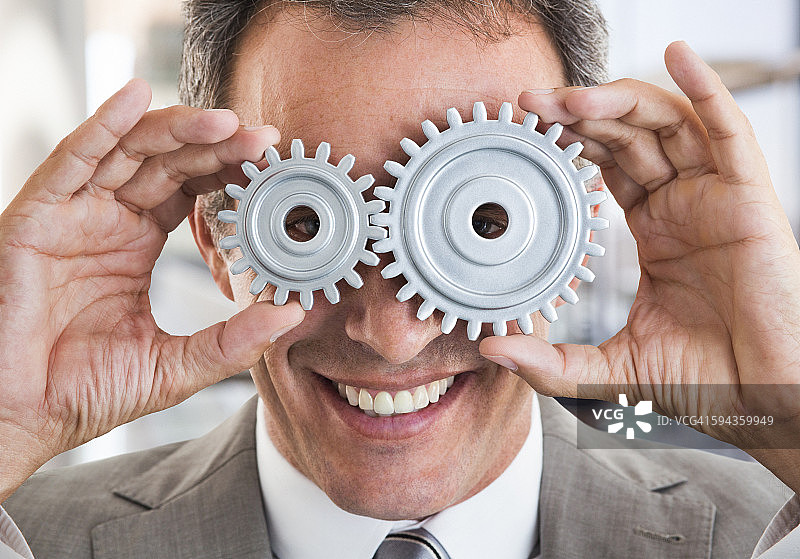 商务男士用齿轮挡住眼睛图片素材