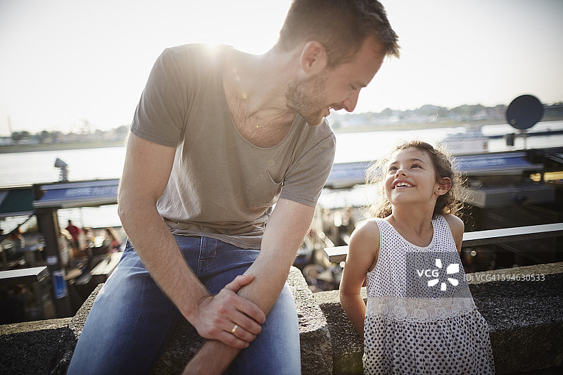 父亲看着逆光中的女儿图片素材