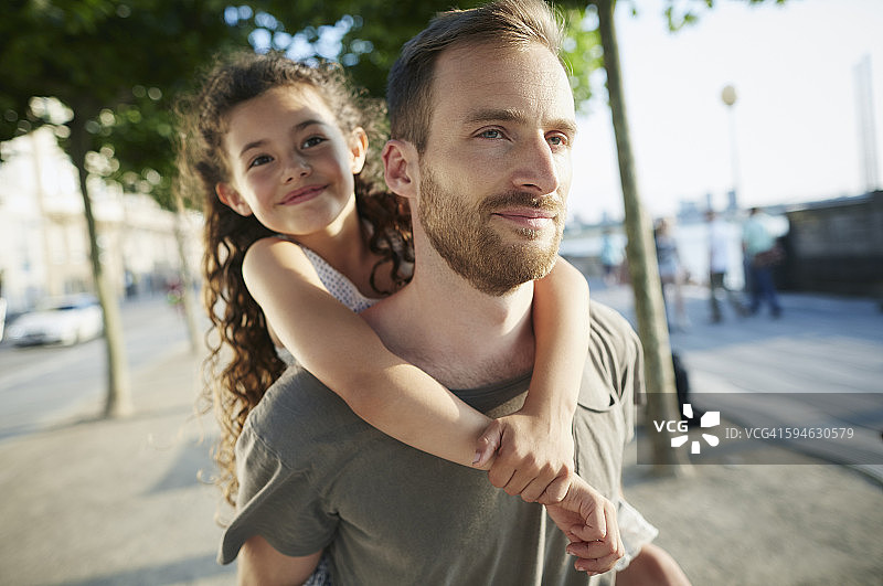 笑容满面的父亲背着女儿图片素材