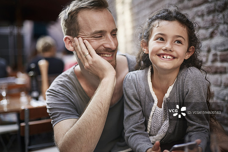笑容满面的父亲和女儿在餐厅图片素材