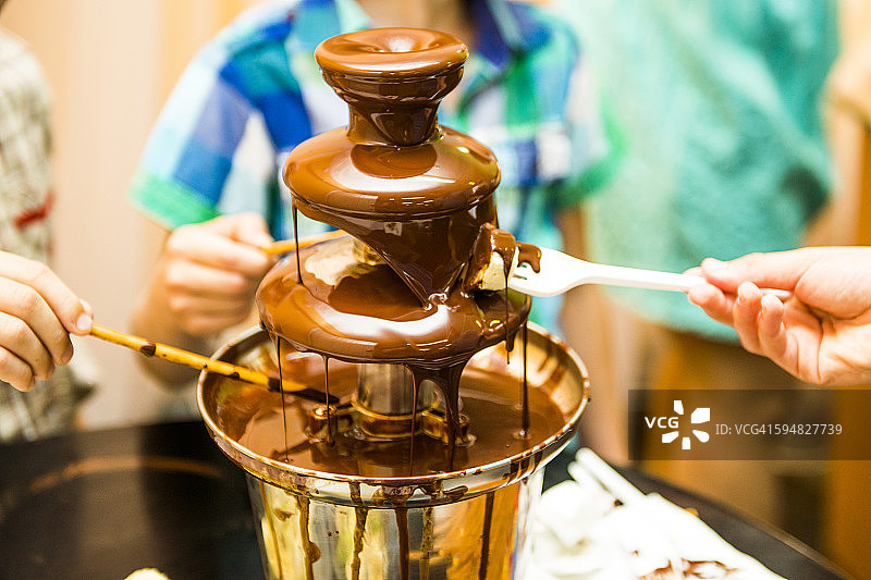 人们在巧克力喷泉旁用餐图片素材