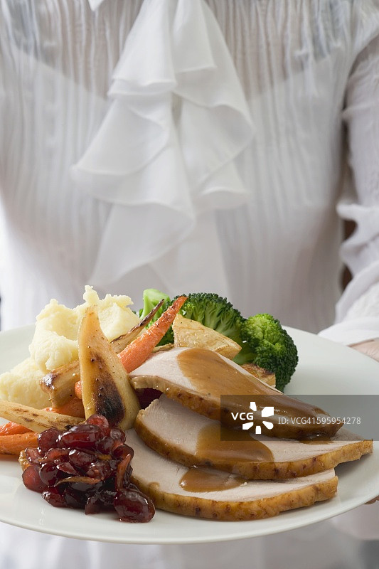 感恩节（美国）女人提供火鸡胸肉和配菜图片素材