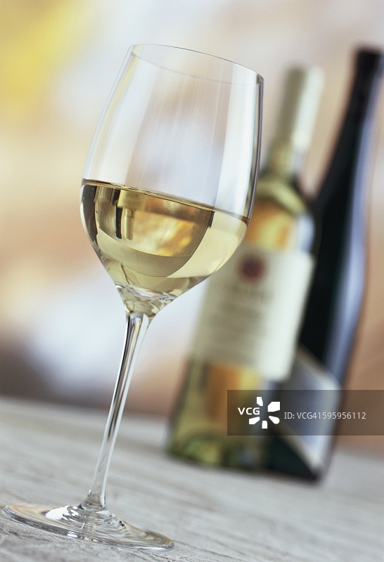 一杯白葡萄酒，后面是白葡萄酒瓶图片素材