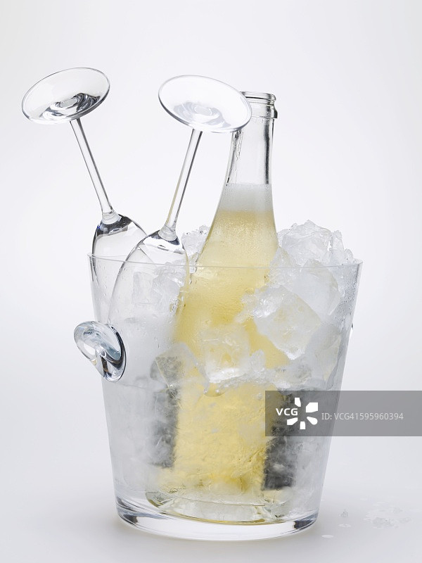 冰桶中的气泡酒瓶和两个空酒杯图片素材