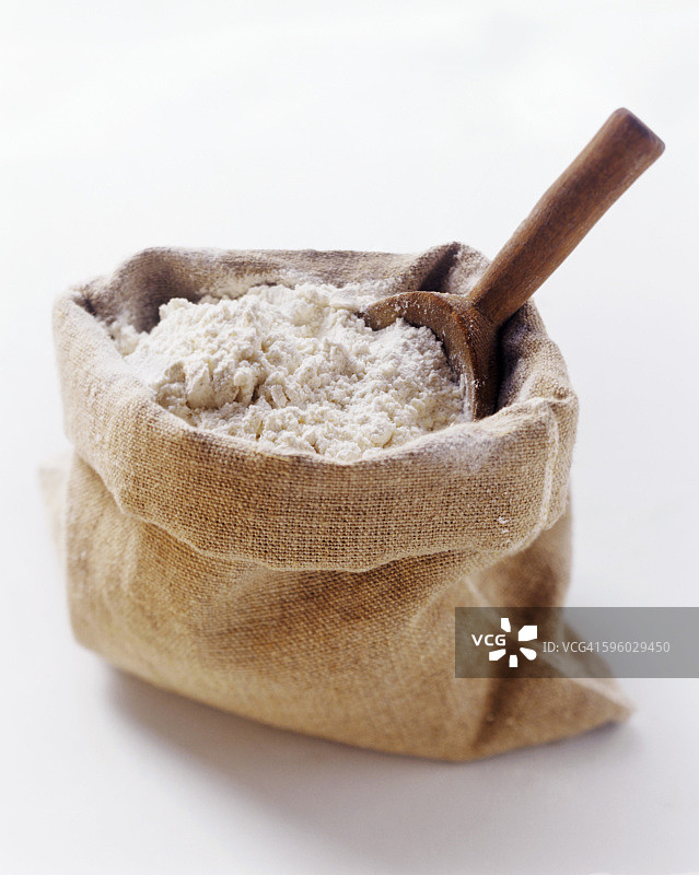 一袋面粉和木制勺子图片素材
