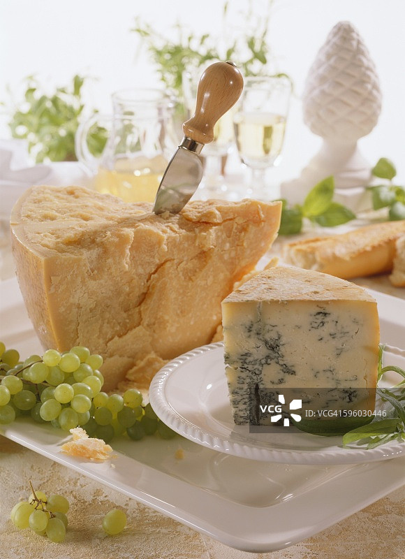 一片古冈左拉奶酪和一片帕尔马干酪，配奶酪刀图片素材