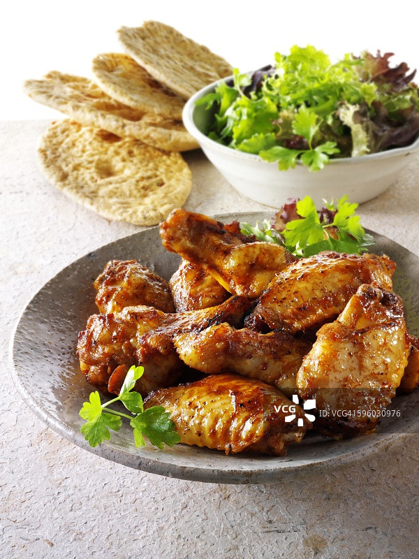 烤鸡翅配沙拉叶和面包图片素材