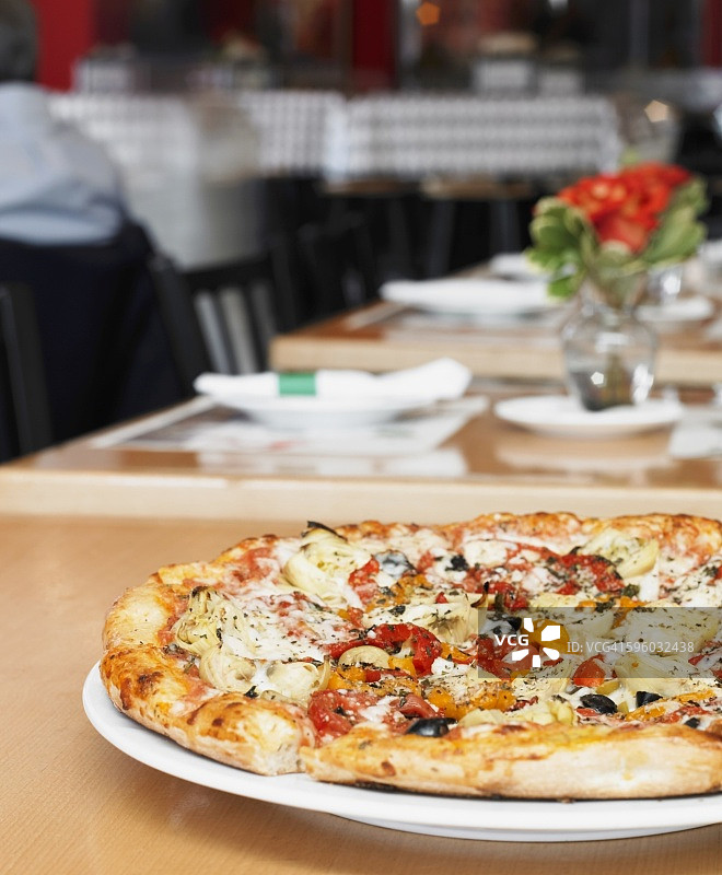 餐厅餐桌上的蔬菜披萨图片素材