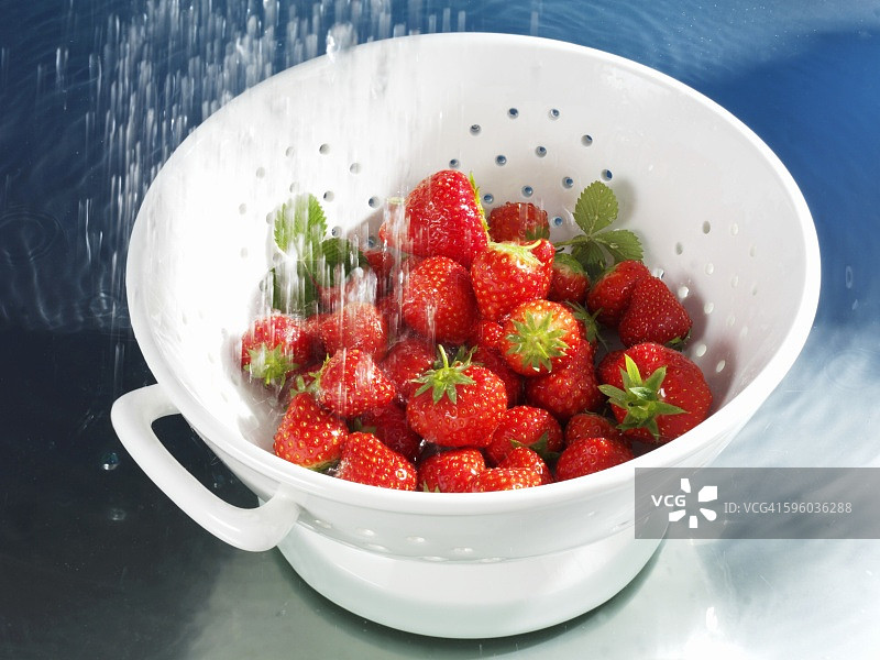 在滤水器中清洗草莓图片素材