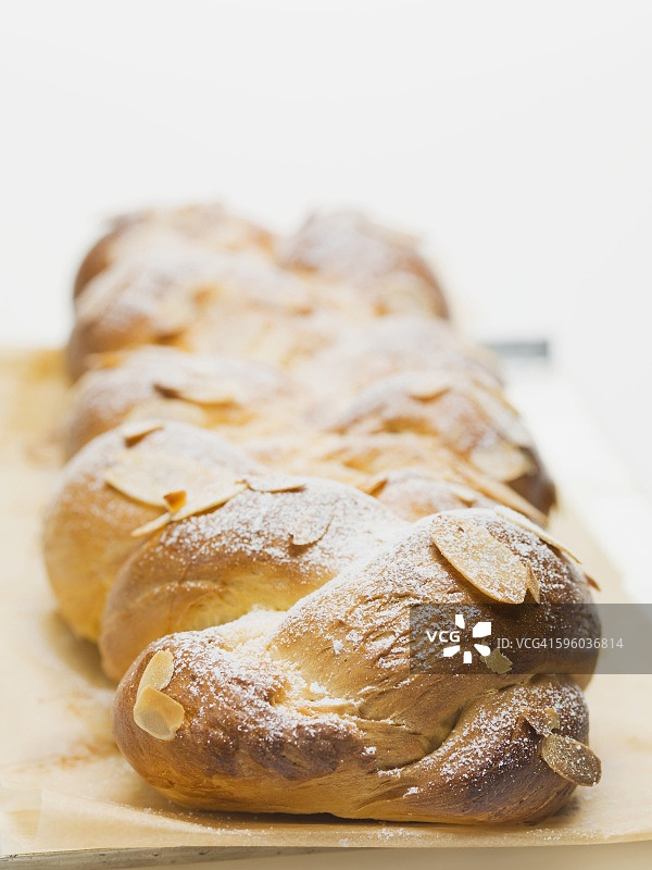 烘焙纸上的杏仁片和糖粉面包图片素材