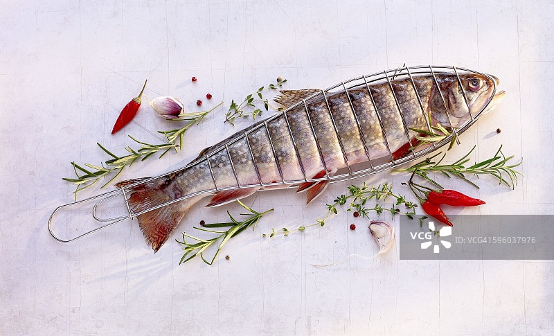 烤篮中带有香草的红点鲑图片素材