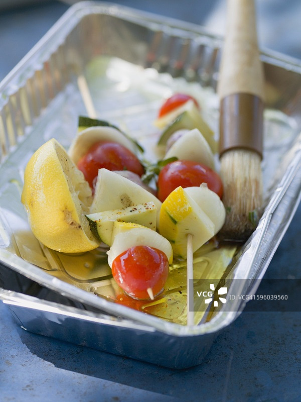 铝盘中配有油和刷子的蔬菜烤串图片素材