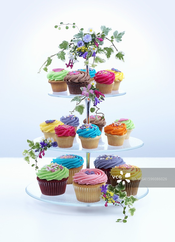 多层蛋糕架上的彩色纸杯蛋糕图片素材