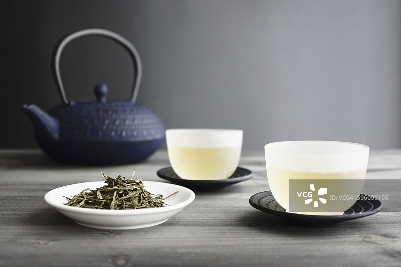 两杯绿茶、散茶和日式茶壶，选择性聚焦图片素材