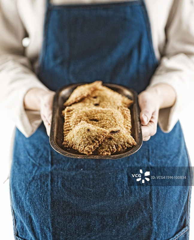 手持迷你黑莓挞小金属盘的人图片素材