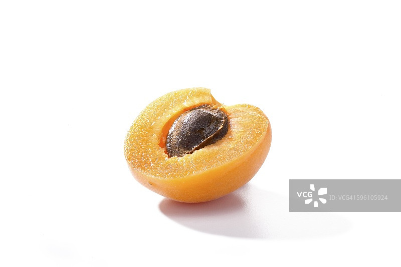 白色背景下的半个带核杏图片素材