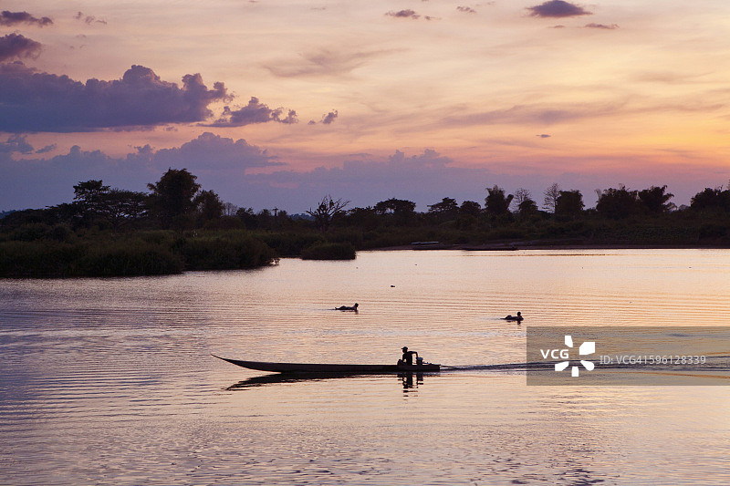 日落时分在湄公河上划皮划艇图片素材