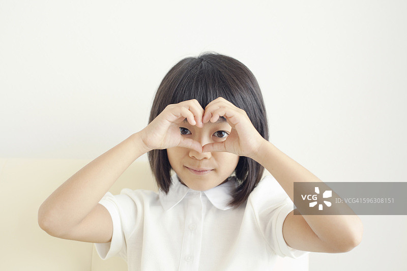 女孩用手在眼睛周围比心图片素材