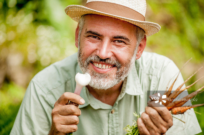 农民手持蔬菜的肖像图片素材