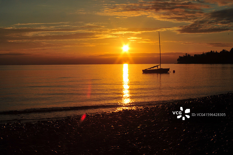 金色日出映衬下的帆船图片素材