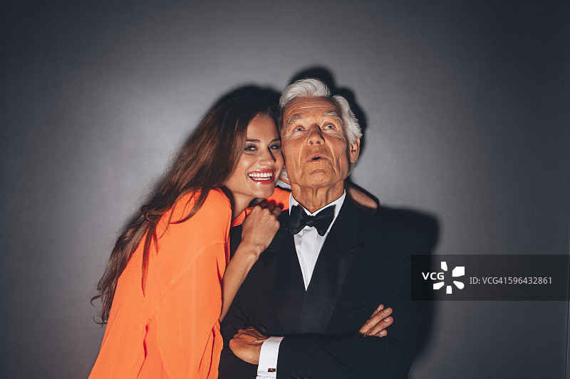 年轻女子拥抱优雅的老年男子图片素材