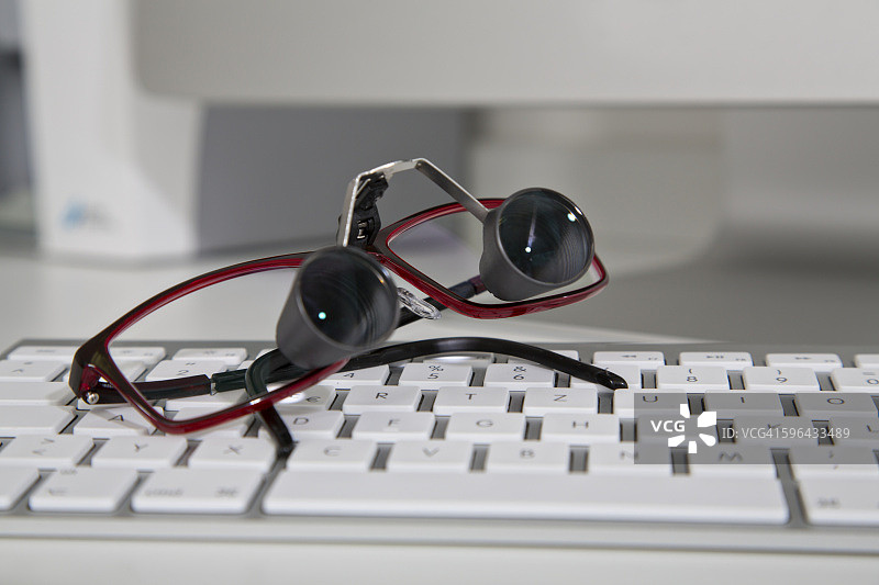 电脑键盘上的医疗光学辅助设备图片素材