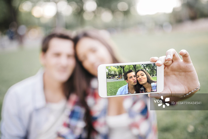 智能手机上显示一对年轻情侣图片素材