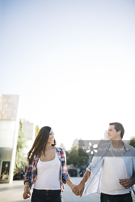 西班牙雷乌斯一对年轻情侣在城市中漫步图片素材