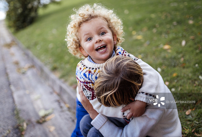 秋天里一起玩耍的两个金发小兄弟图片素材