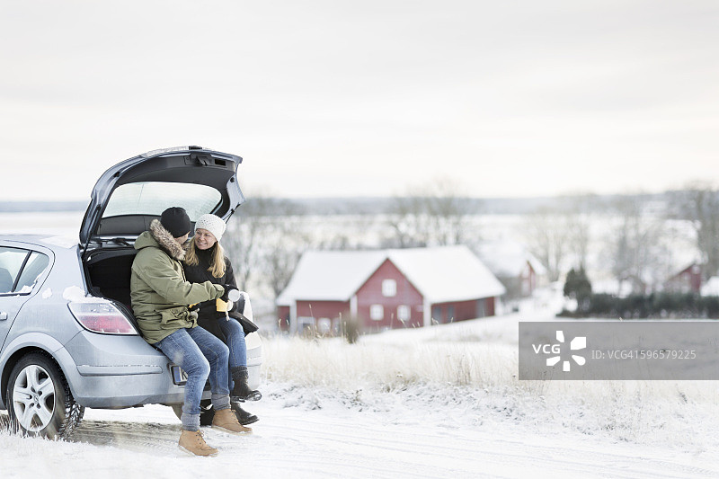 微笑情侣坐在敞开的后备箱里图片素材