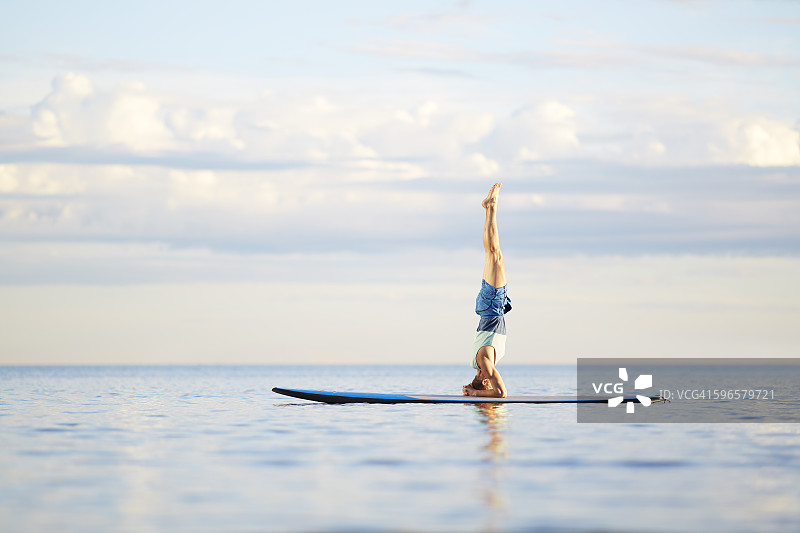 男子在桨板上做瑜伽图片素材