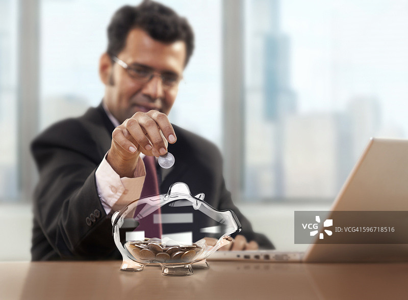 商人将硬币放入储蓄罐图片素材