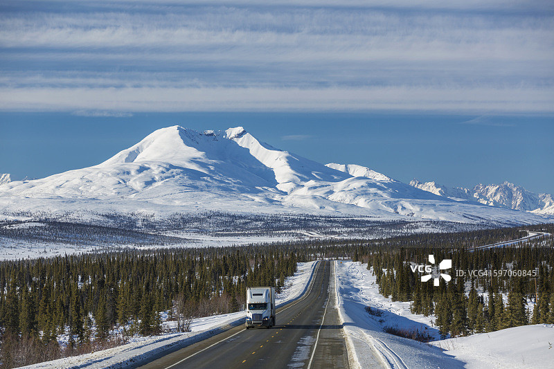 一辆半挂卡车行驶在阿拉斯加州中南部尤里卡附近的格伦高速公路上，冬季图片素材