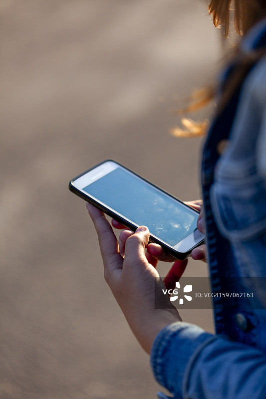 少女手持智能手机图片素材