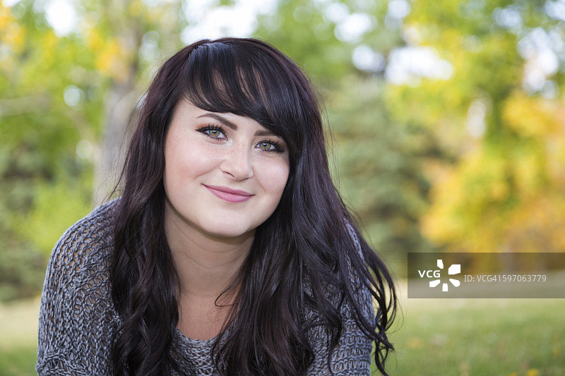 秋季城市公园里美丽的年轻女子户外肖像图片素材