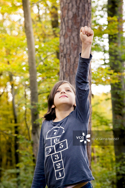 女孩在树林里扮演女超人的肖像图片素材