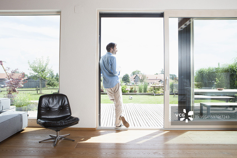 年长的男人倚靠在花园门边，后视图图片素材