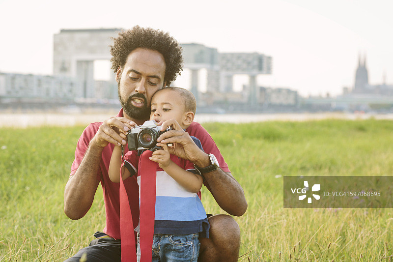 德国科隆：父亲在田野里向儿子讲解相机图片素材