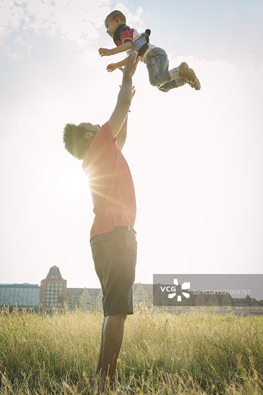 德国科隆：父亲在田野里抛起他的儿子图片素材
