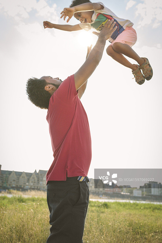 德国科隆：父亲在田野里抛起他的儿子图片素材