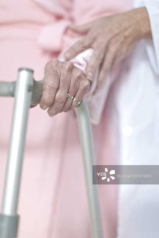 老年患者在步行架的支撑下行走图片素材