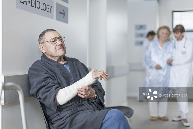 手臂绑着绷带的老年患者在医院等待图片素材
