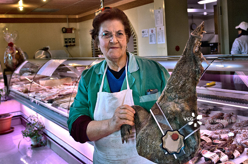 熟食店老板展示传统的意大利熏火腿，意大利撒丁岛图片素材