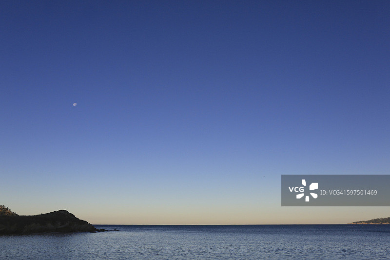 太平洋上空的月亮/日出/蓝色地平线图片素材