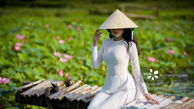 荷花池边身穿奥黛的越南女孩图片素材