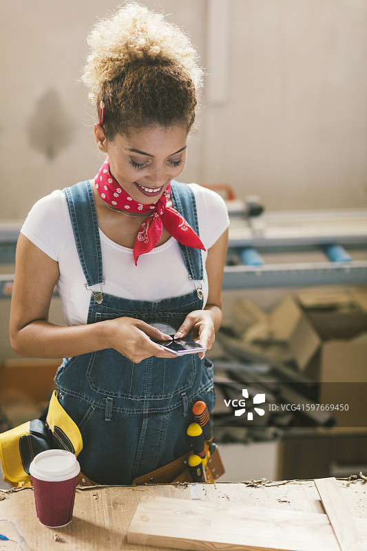 在工作室发短信的拉丁裔木匠图片素材