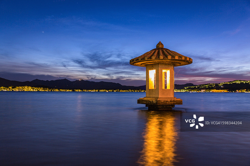 中国杭州西湖的石灯笼在黄昏时亮起图片素材