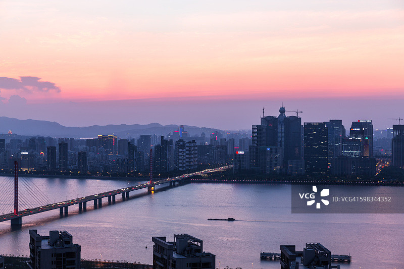 运输船在钱塘江上航行，背景是杭州市中心天际线图片素材