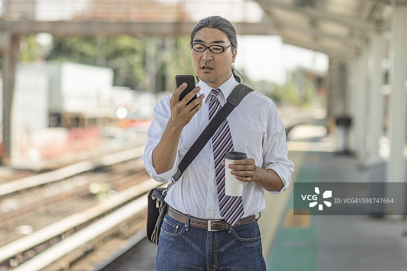 在通勤列车站台上工作的现代商务男士图片素材