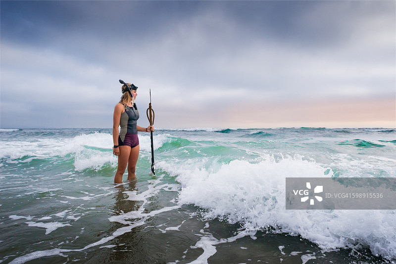 站在海里用鱼叉捕鱼的女人图片素材